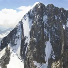 Majestätische Grandes Jorasses, zerklüftete Felsen mit Schneefeldern, die sich an steilen Hängen entlangziehen.