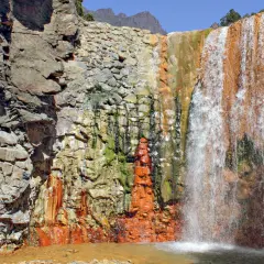 Farbenprächtiger Wasserfall mit rostfarbenen Felsen, ideal für la palma wandern. Ein Naturjuwel.