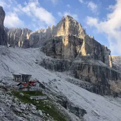Hütte in den Brenta Dolomiten, umgeben von steilen Felswänden und Geröllfeldern. Ein majestätischer Anblick.
