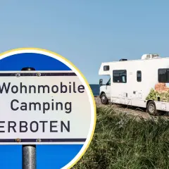 Schild: Wohnmobile Camping VERBOTEN. Ein Wohnmobil steht am Meer, aber hier ist kein Platz für strafe wildcampen.