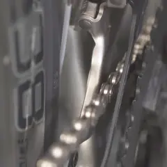 Nahaufnahme: Campagnolo Umwerfer einstellen. Die Kette liegt auf den Kettenblättern, der Umwerfer ist nah dran.