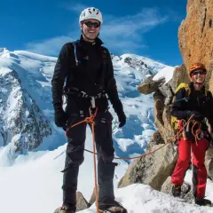 Zwei Bergsteiger auf dem Weg zur Mont Blanc Besteigung, umgeben von Schnee und Felsen.