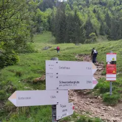 Wegweiser für eine Schrecksee Wanderung: Giebelhaus, Schwarzenberghütte und Hinterstein sind Ziele. Wanderer steigen bergauf.