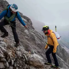 Zwei Bergsteiger sichern sich gegenseitig auf dem steinigen Weg zum Zugspitze Gipfel.