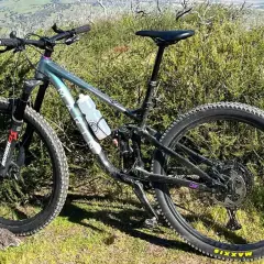 Ein Mountainbike steht im Grünen. Es ist bereit für Abenteuer, vielleicht sogar für eine Runde Cyclocross, wo solche robusten Räder ihre Stärken ausspielen.