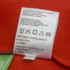 Pflegeetikett einer roten Softshell-Jacke. Hinweise zur Wäsche, z.B. 30°C, kein Trockner.