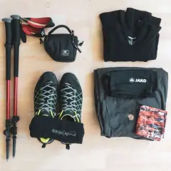 Wanderausrüstung: Stöcke, Schuhe, Socken, Tasche, Shirt, Hose und ein Tuch. So weiß ich, was ich zum Wandern brauche.