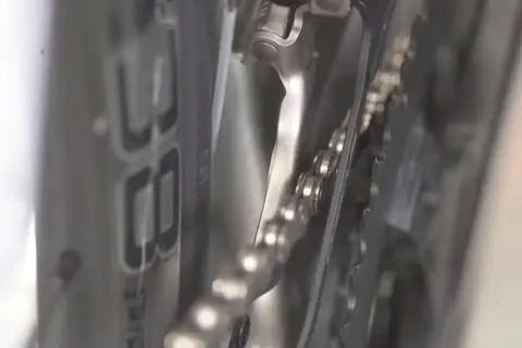 Nahaufnahme: Campagnolo Umwerfer einstellen. Die Kette liegt auf den Kettenblättern, der Umwerfer ist nah dran.