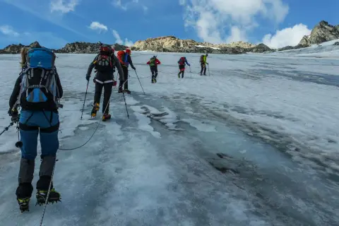 Bergsteiger seilen sich auf dem Weg zum Piz Buin über einen eisigen Gletscher ab.