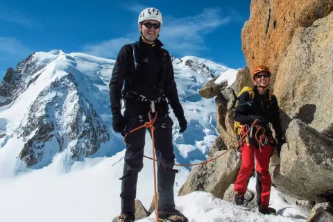 Zwei Bergsteiger auf dem Weg zur Mont Blanc Besteigung, umgeben von Schnee und Felsen.