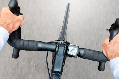 Hände greifen den Rennradlenker, während der Radcomputer 29,2 km/h anzeigt.