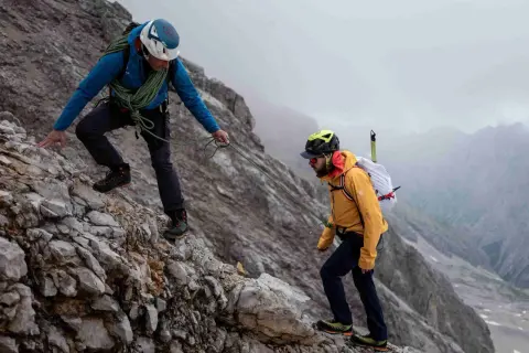 Zwei Bergsteiger sichern sich gegenseitig auf dem steinigen Weg zum Zugspitze Gipfel.