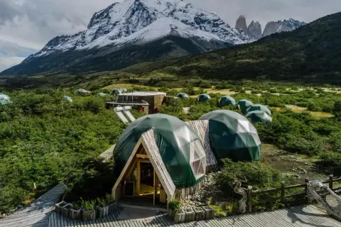 Glamping-Dörfer am Fuße schneebedeckter Berge, ideal für den Torres del Paine W Trek.