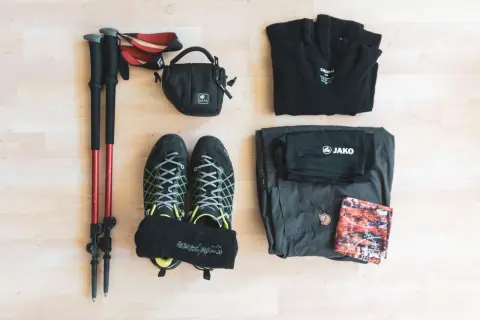 Wanderausrüstung: Stöcke, Schuhe, Socken, Tasche, Shirt, Hose und ein Tuch. So weiß ich, was ich zum Wandern brauche.