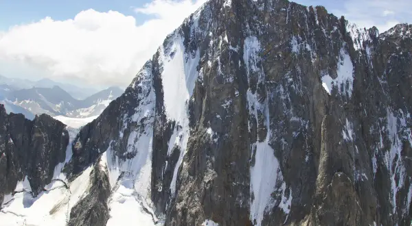 Majestätische Grandes Jorasses, zerklüftete Felsen mit Schneefeldern, die sich an steilen Hängen entlangziehen.