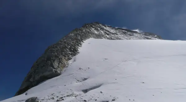 Der Olperer Nordgrat im Sonnenschein. Eine Spur im Schnee führt den Berg hinauf.