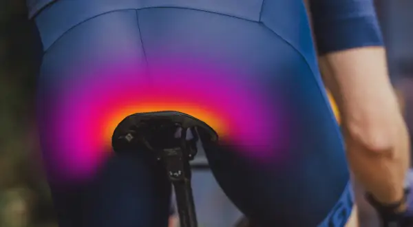 Radfahrer mit schmerzenden Sitzknochen nach langer Tour. Die bunte Überlagerung zeigt den Druckbereich auf dem Sattel.