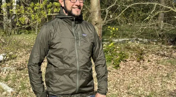 Mann mit Fahrradhelm und Patagonia Regenjacke im Wald. Die Jacke ist leicht und ideal für Outdoor-Abenteuer.