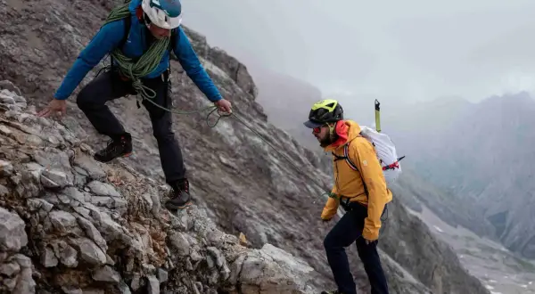 Zwei Bergsteiger sichern sich gegenseitig auf dem steinigen Weg zum Zugspitze Gipfel.