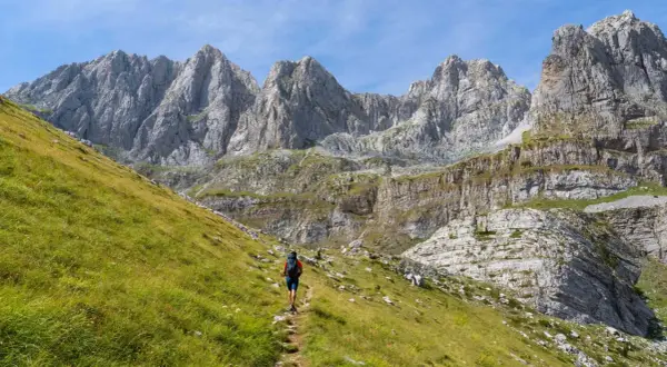 Wanderer auf einem Pfad im **high scardus trail** vor imposanten Felsformationen.
