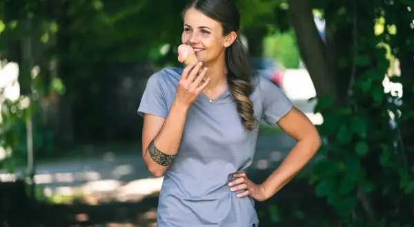 Frau genießt ein Eis im Sommer, trägt ein Shirt aus **Merinowolle im Sommer**.