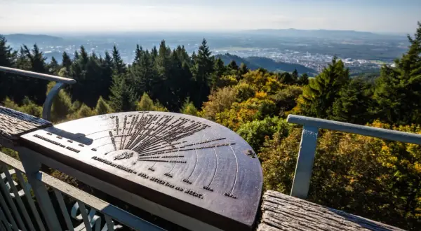 Panoramablick vom Aussichtspunkt Rosskopf Freiburg mit einer Orientierungstafel, die auf die umliegenden Berge und Täler hinweist.