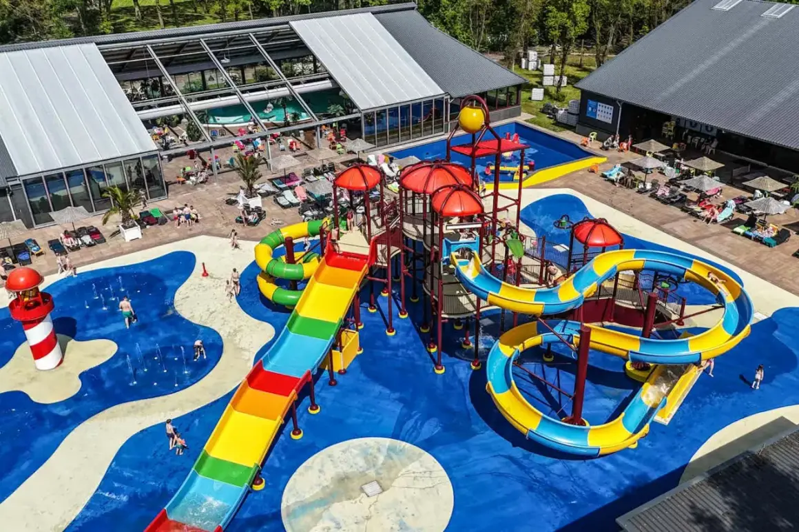 Bunter Wasserrutschen-Spaß auf einem Campingplatz mit Pool im Allgäu. Kinder planschen und rutschen ausgelassen.