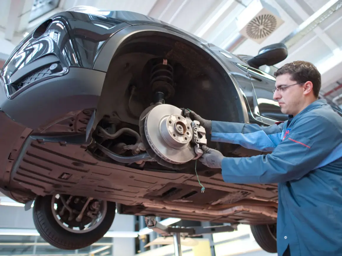 Mechaniker arbeitet am quietschenden Vorderrad eines Autos.