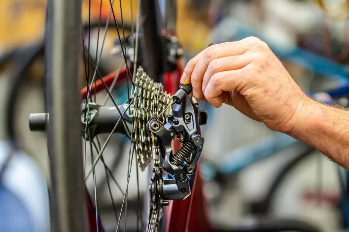Hand stellt Shimano 105 Schaltwerk ein. Präzise Justierung für reibungsloses Schalten.