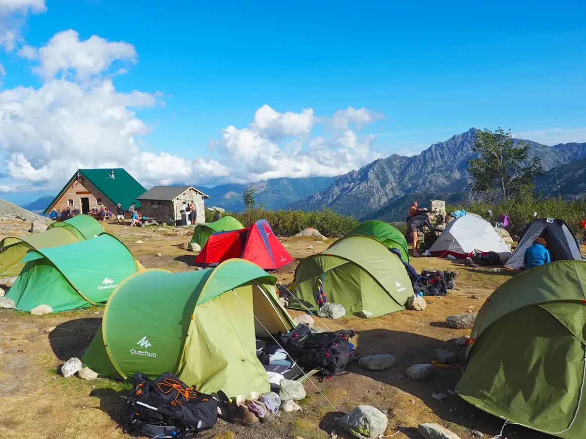 Zelte am korsika wanderweg. Bergpanorama, Berghütte und Camper genießen die Aussicht.