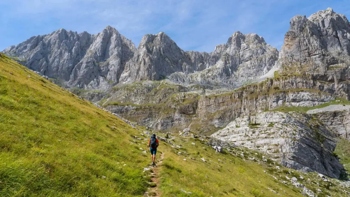 Wanderer auf einem Pfad im **high scardus trail** vor imposanten Felsformationen.
