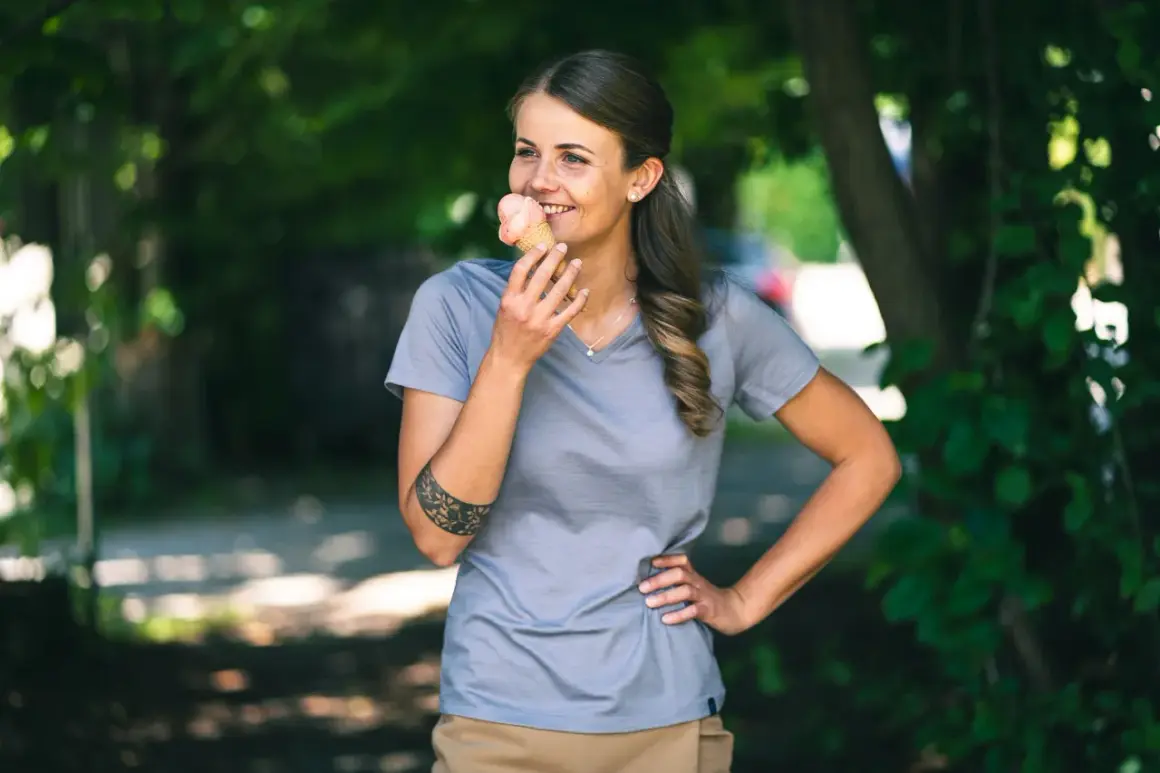 Frau genießt ein Eis im Sommer, trägt ein Shirt aus **Merinowolle im Sommer**.