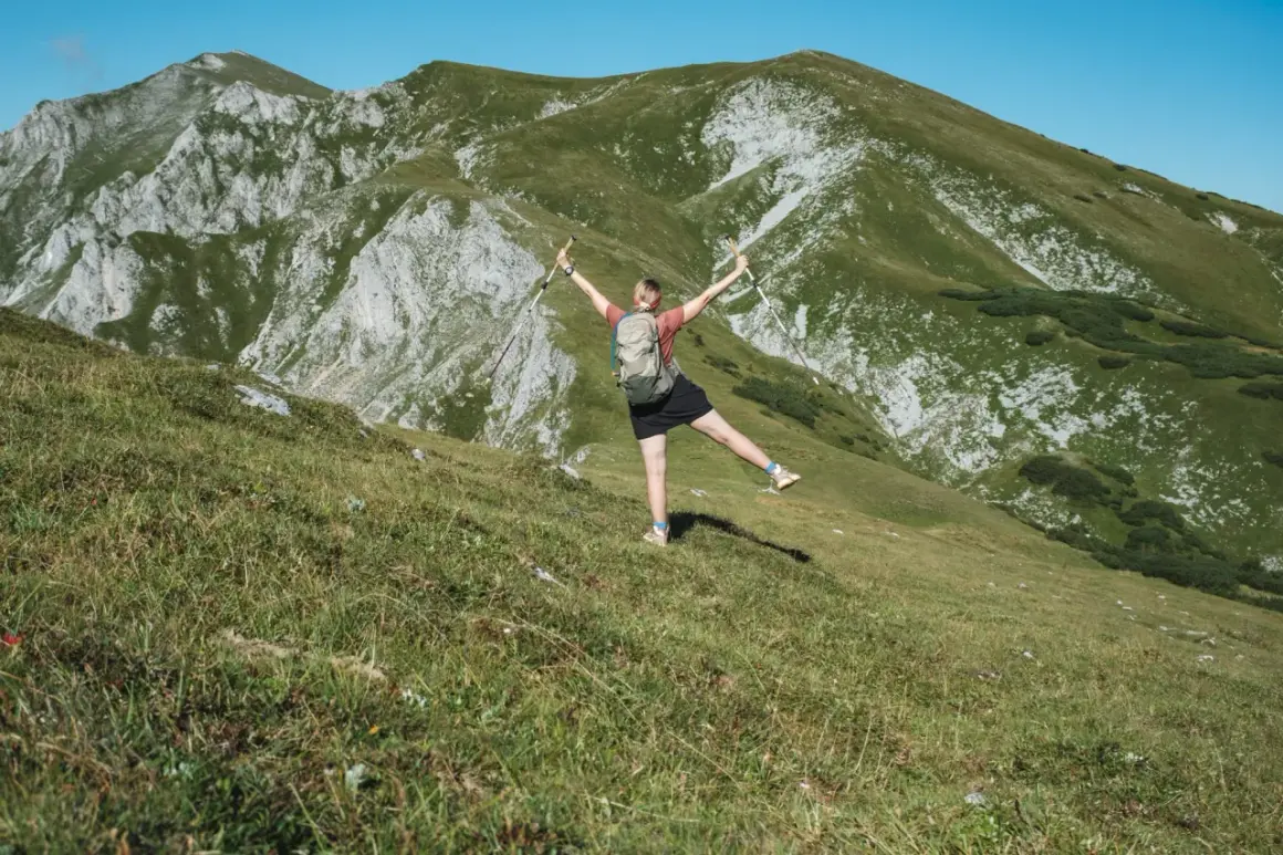 Glückliche Wanderin mit erhobenen Armen und Stöcken genießt die Aussicht auf die Berge beim Wandern in Polen.