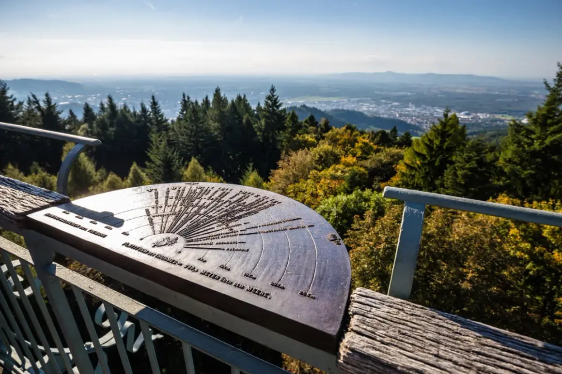Panoramablick vom Aussichtspunkt Rosskopf Freiburg mit einer Orientierungstafel, die auf die umliegenden Berge und Täler hinweist.