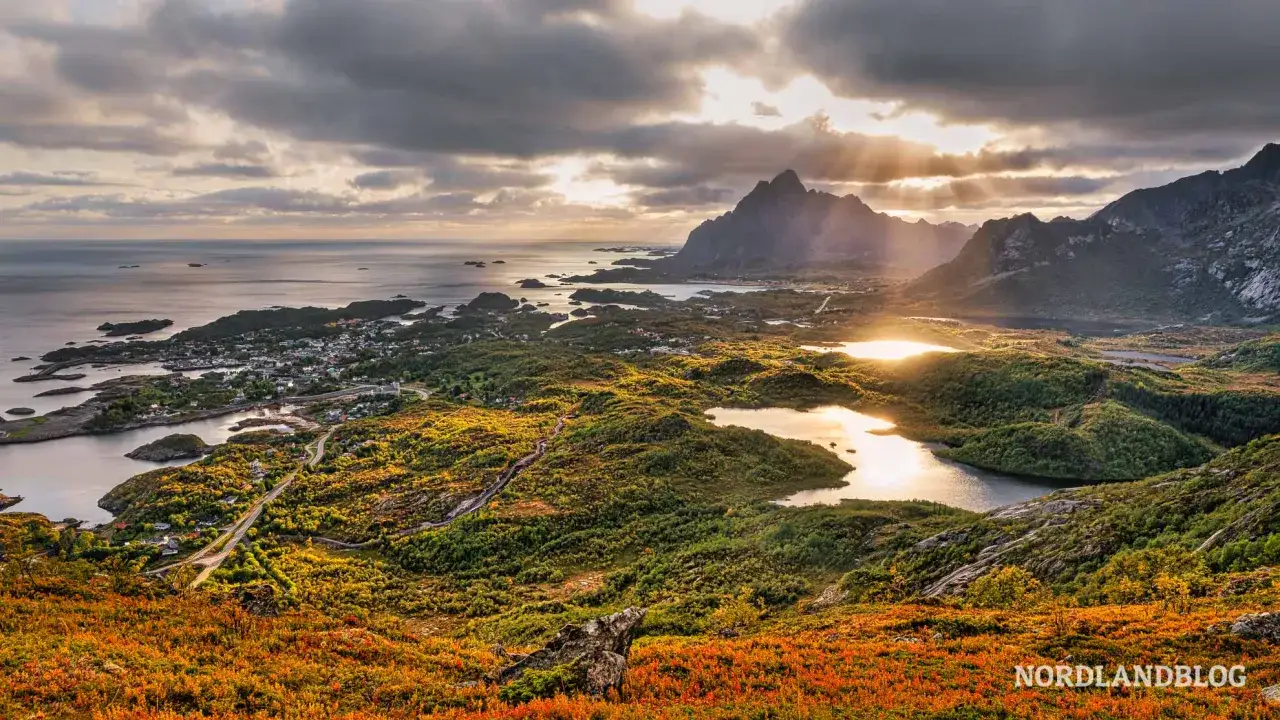 Herbstliche Farben auf den Lofoten, die beste Reisezeit f&uuml;r dramatische Landschaften und goldenes Licht. Ein Dorf am Meer unter majest&auml;tischen Bergen.