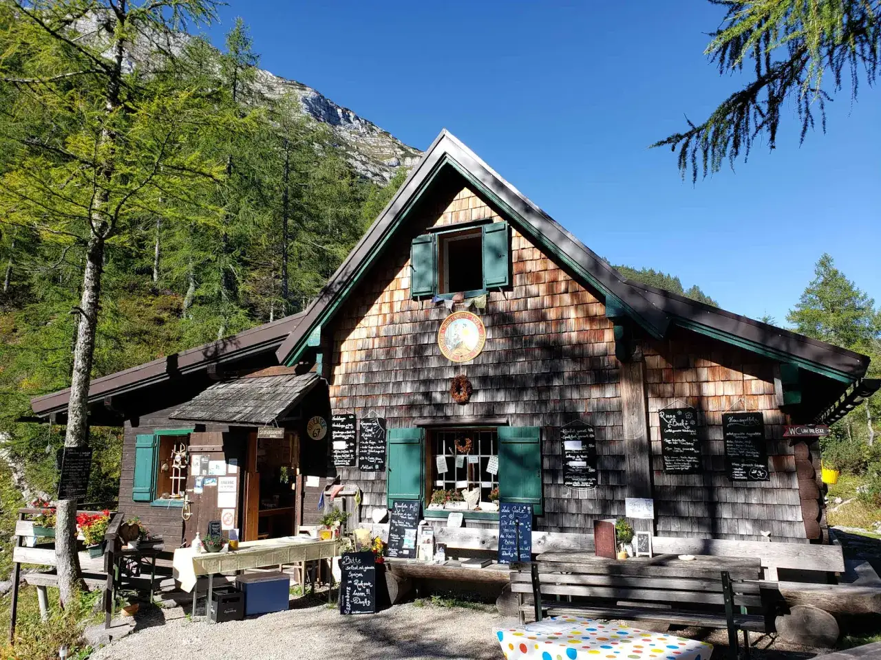 Holzhütte am Berg mit vielen Menütafeln. Ein idyllischer Ort im toten Gebirge, perfekt für eine Rast.