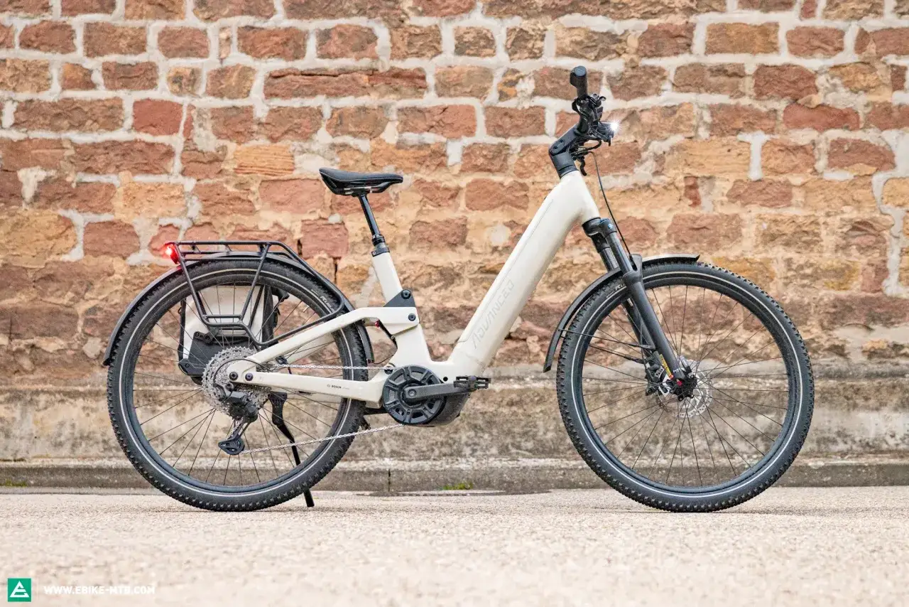 Ein beiges E-Bike mit Gepäckträger und Federgabel. Dieses