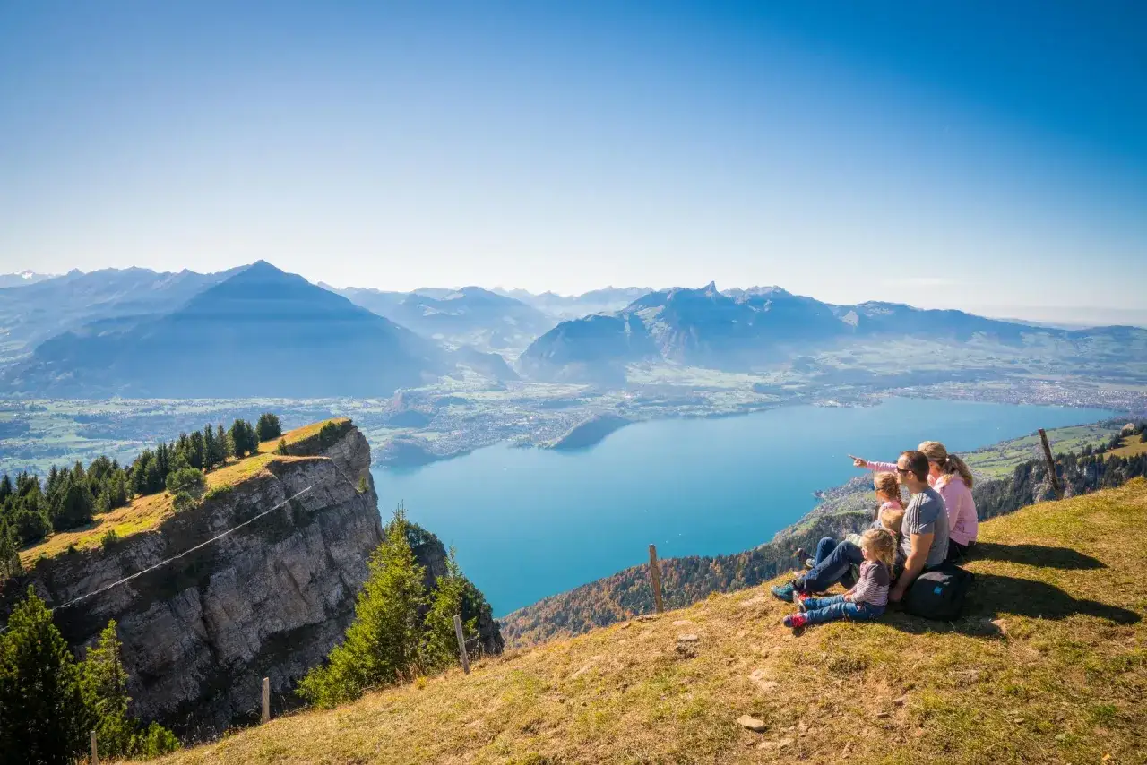 Familie genießt atemberaubende Aussicht auf den Thunersee und die Berner Alpen.