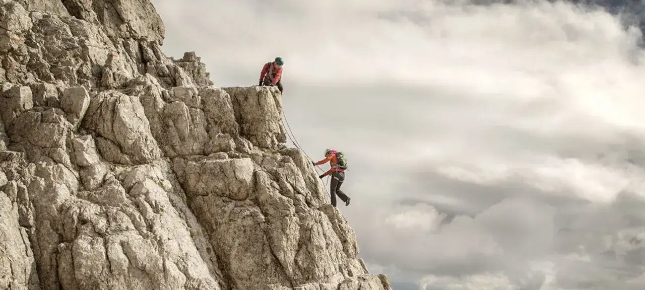 Zwei Bergsteiger meistern eine anspruchsvolle Route im Klettern in den Dolomiten.