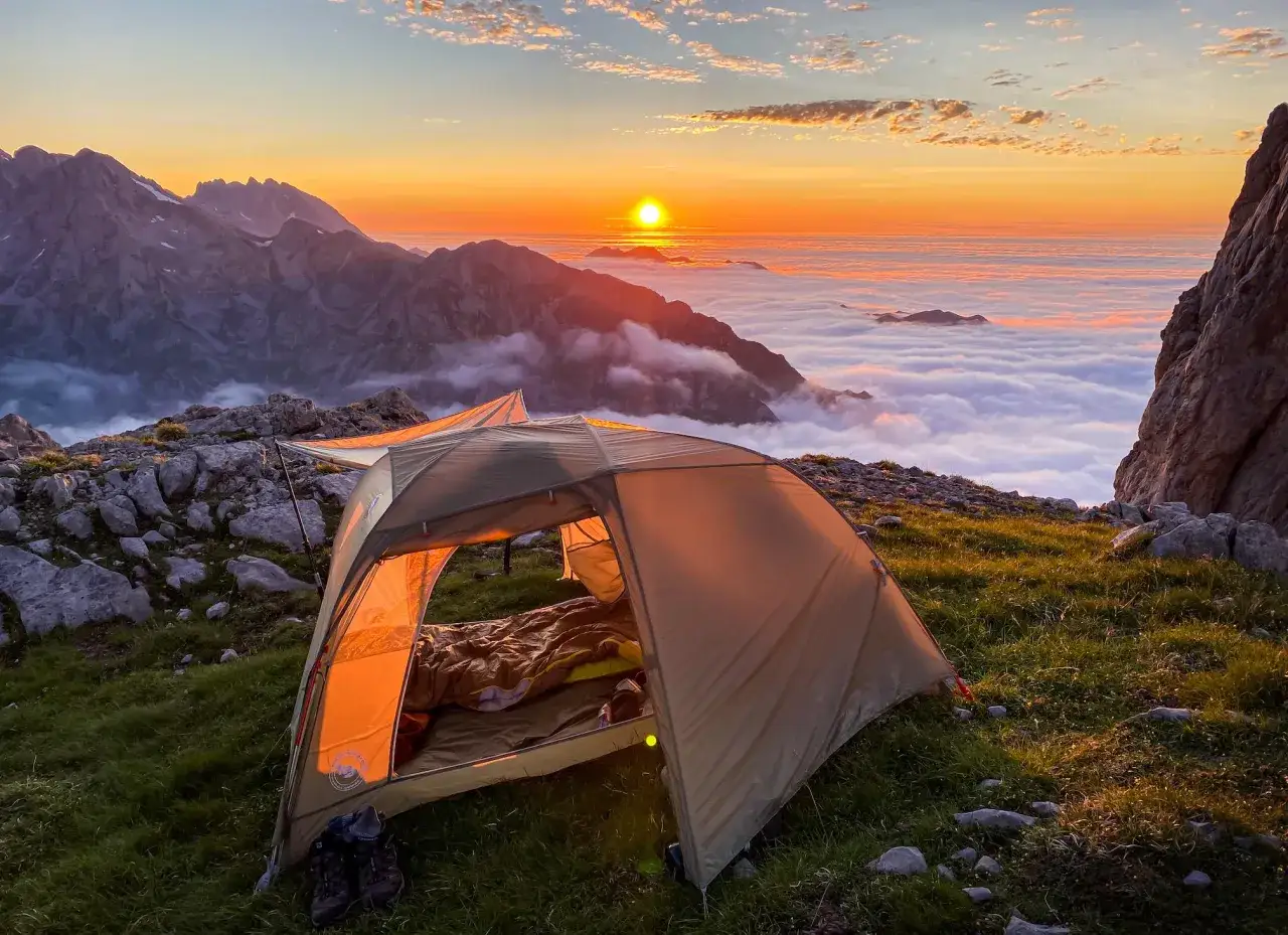 Zelt im Sonnenaufgang über Wolkenmeer in den spanischen Bergen. Ein Traum für jeden, der wildcampen in Spanien liebt.