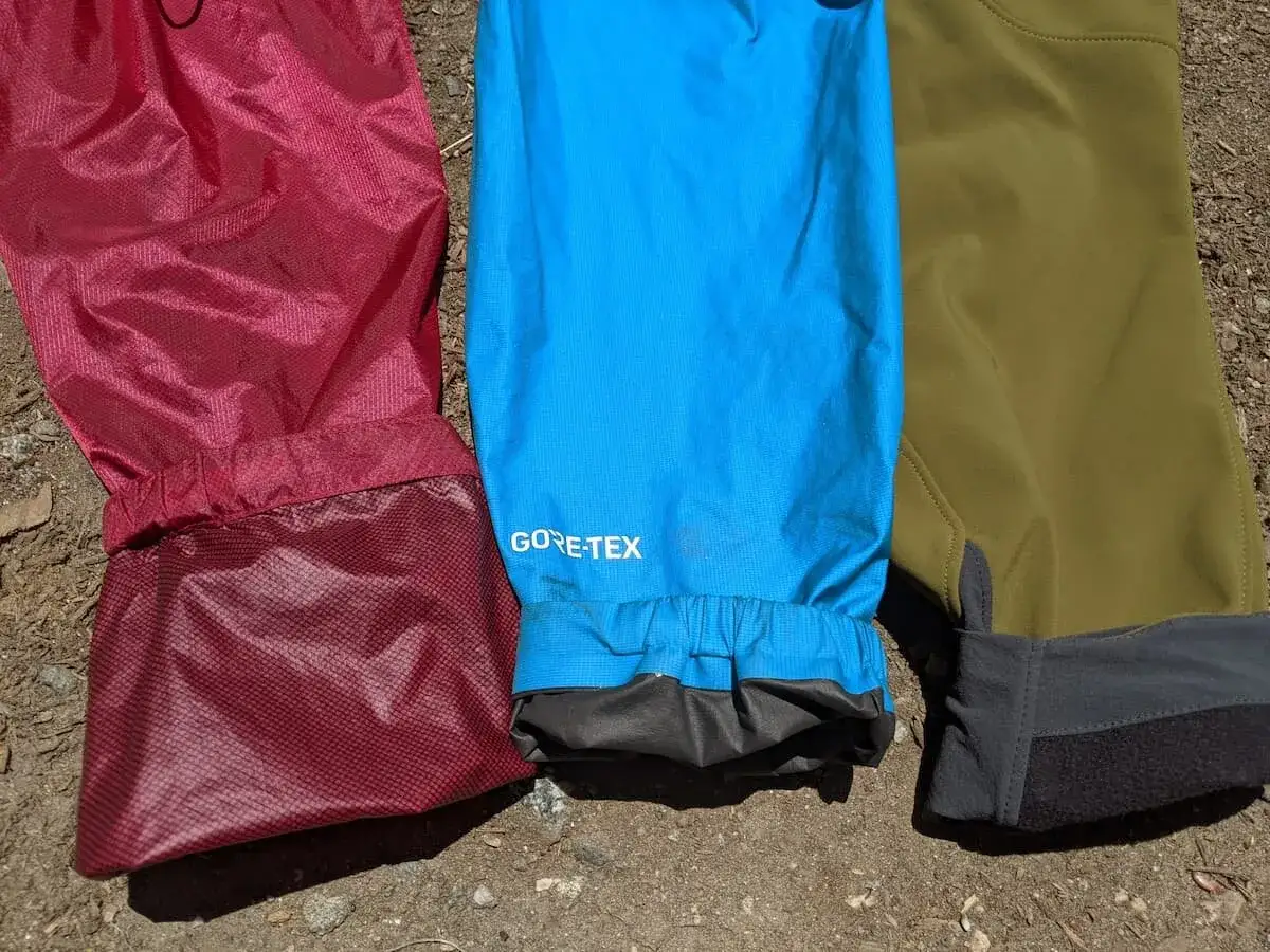 Drei Hosenbeine in Rot, Blau und Olivgrün. Das blaue Bein trägt das GORE-TEX Logo, ein Hinweis auf die richtige Gore Tex Pflege für Langlebigkeit.