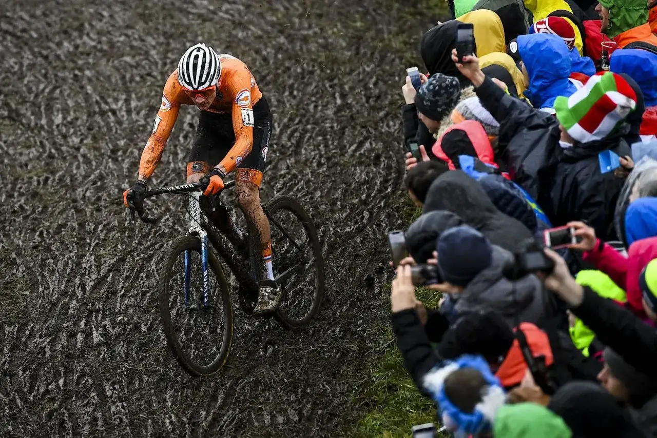 Ein Radfahrer k&auml;mpft sich durch Schlamm, w&auml;hrend Zuschauer mit Handys filmen. Das ist Cyclocross: ein Rennen durch schwieriges Gel&auml;nde.