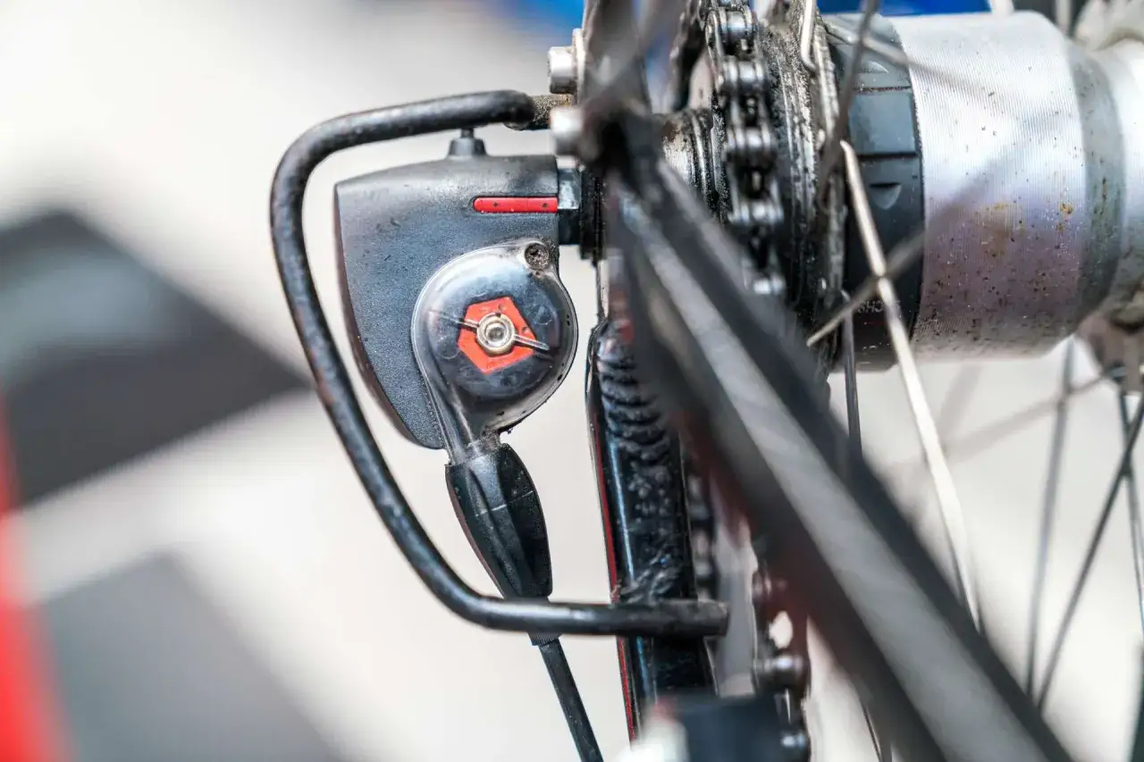 Nahaufnahme des Schaltwerks einer Nabenschaltung am Fahrrad. Die rote Markierung deutet auf die korrekte Einstellung hin.
