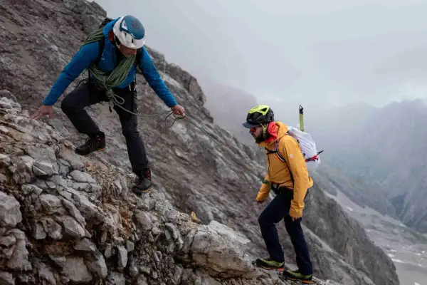 Zwei Bergsteiger sichern sich gegenseitig auf dem steinigen Weg zum Zugspitze Gipfel.